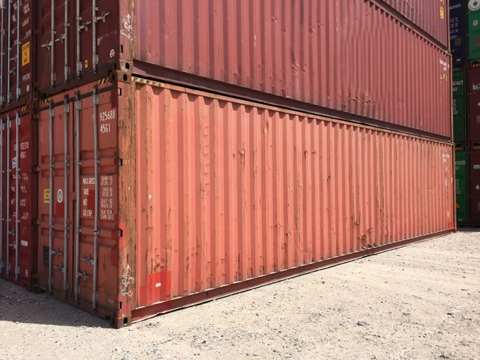 two shipping containers stacked in a shipyard