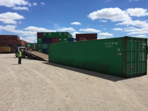 green 40ft shipping container for sale at intermodal depot, 40ft shipping container loaded onto a truck for delivery, used 40ft shipping containers for sale, 40ft conex containers for sale, buy shipping containers